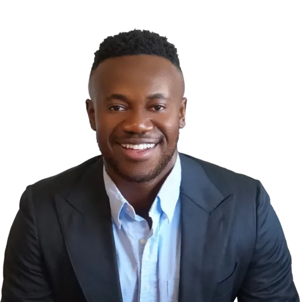 A smiling man named Alex Dwomoh wearing a suit with an open-collar shirt.