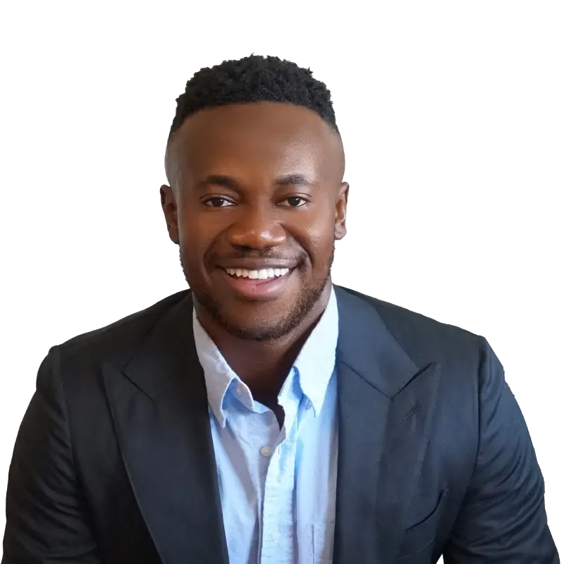 A smiling man named Alex Dwomoh wearing a suit with an open-collar shirt.