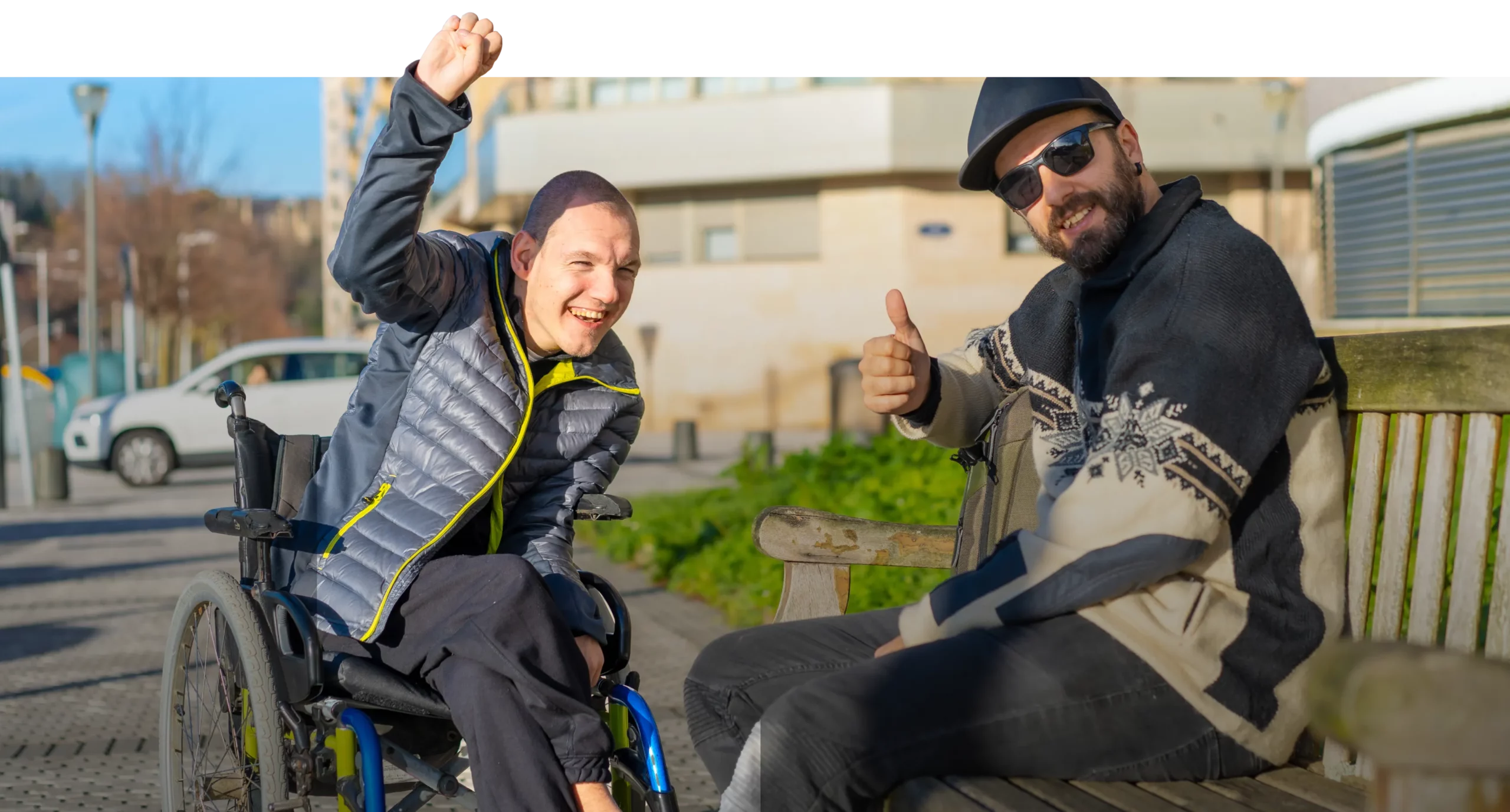 A man in a wheelchair is giving a thumbs up to another man.