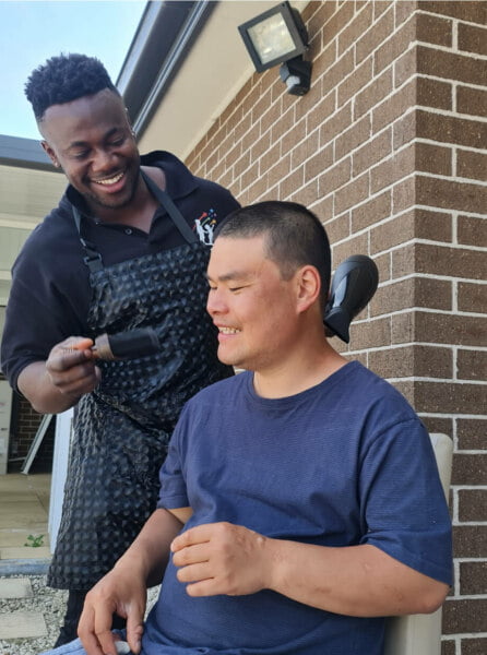 A man is getting his hair cut by a barber.