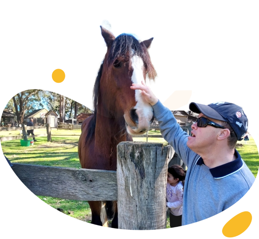 A man petting a horse near a fence.