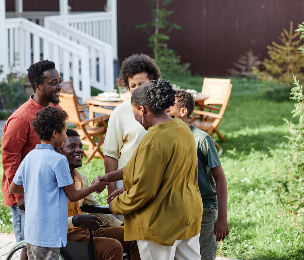 A group of people standing around a man in a wheelchair.