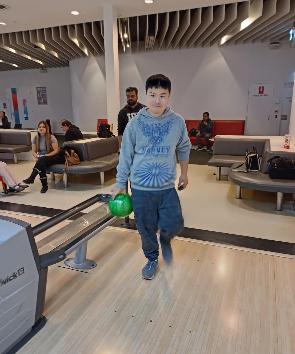 A young man bowling in a bowling alley.